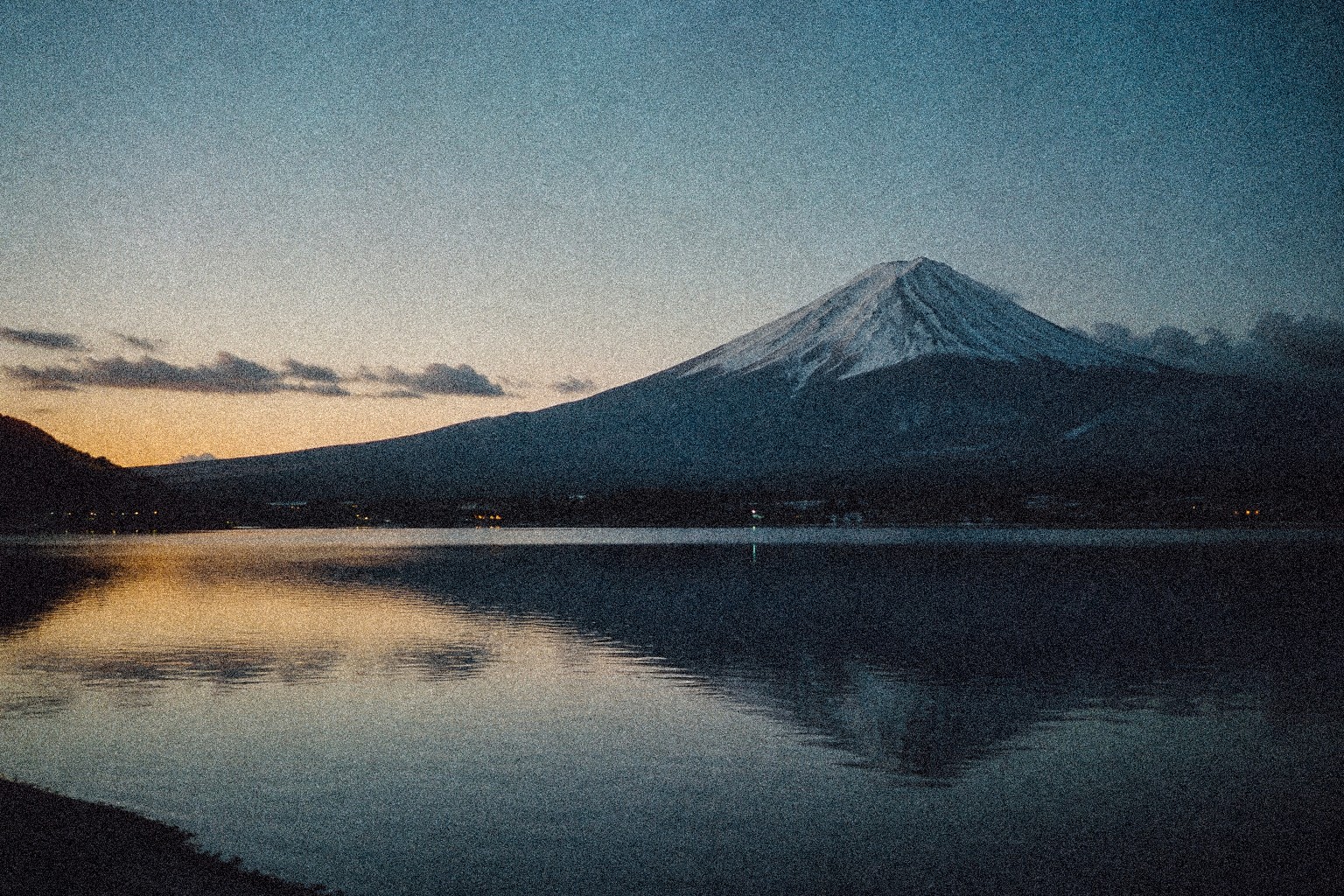 Mount Fuji at dawn across still water