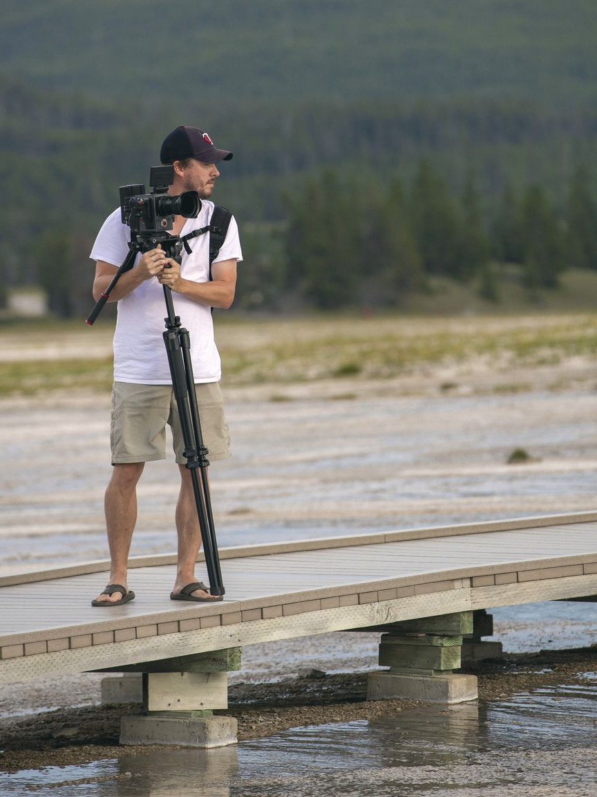 Adam Grumbo filming on a boardwalk